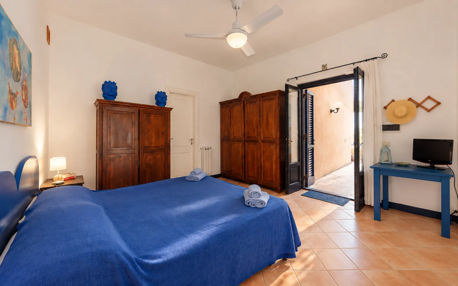 La camera matrimoniale blu con la portafinestra aperta