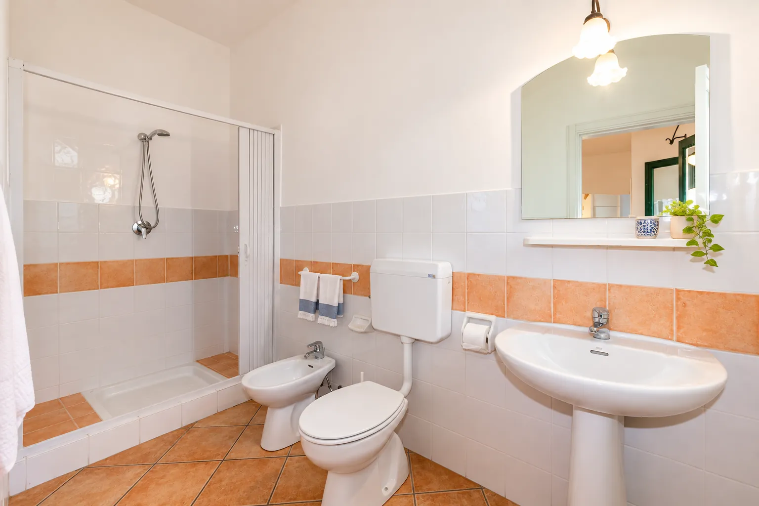 Il bagno con doccia e fascia di maioliche terracotta