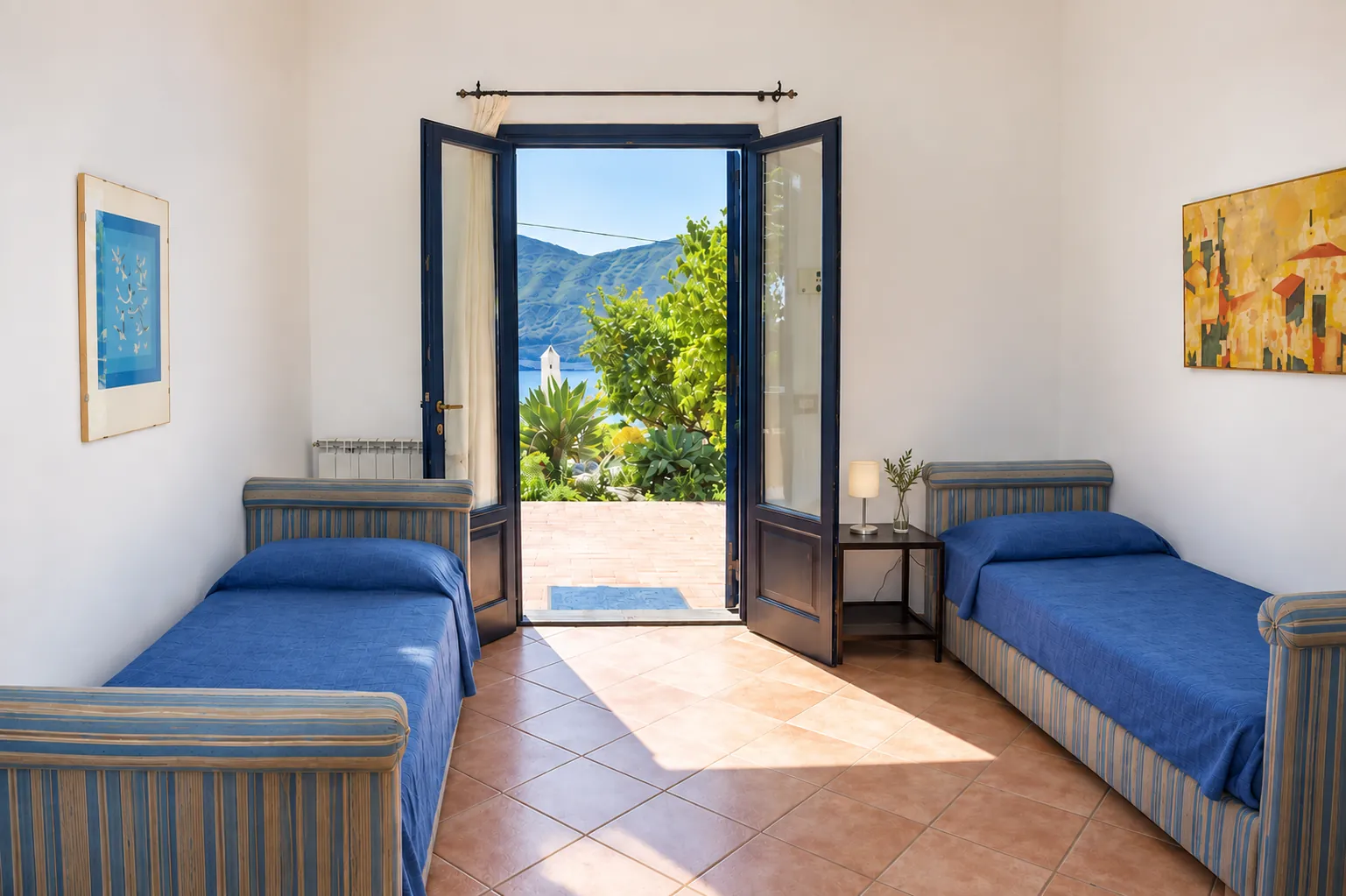 La seconda zona notte con due letti singoli e la porta aperta sul giardino