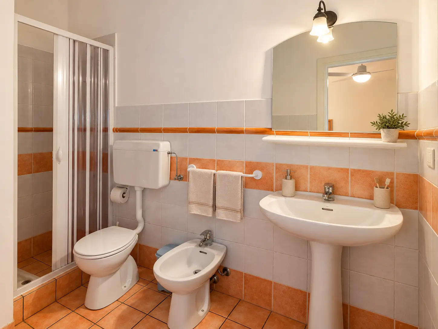 Il bagno con doccia e maioliche color terracotta