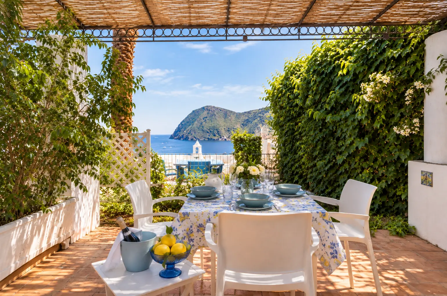 La tavola apparecchiata in terrazza con la baia sullo sfondo