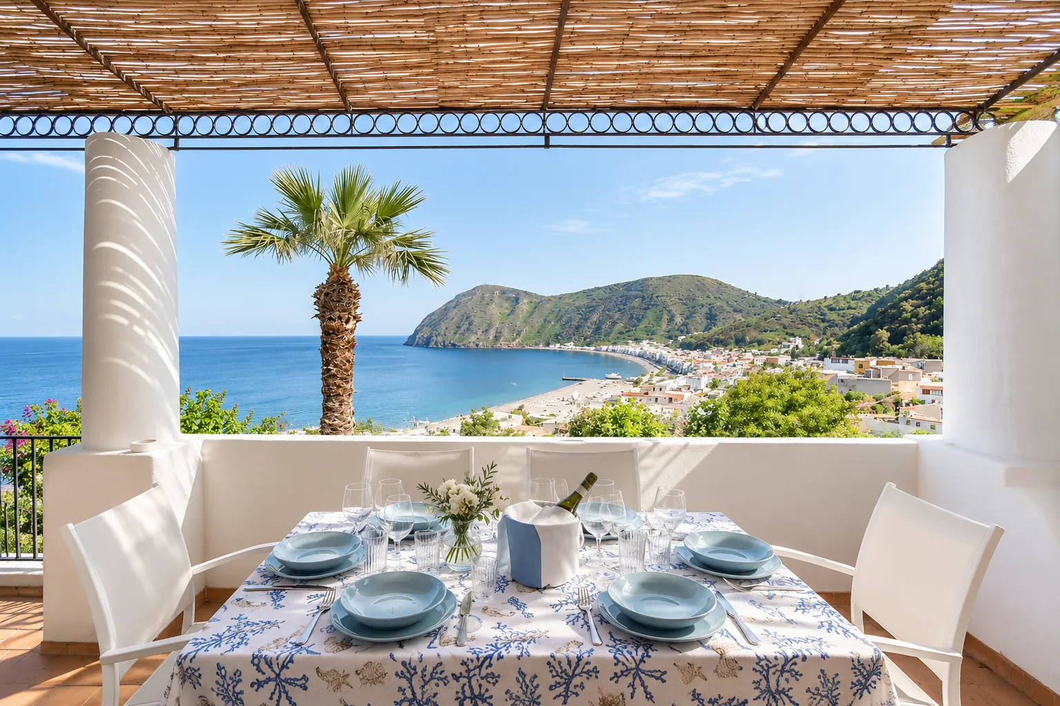 La tavola apparecchiata sulla terrazza coperta, con la baia