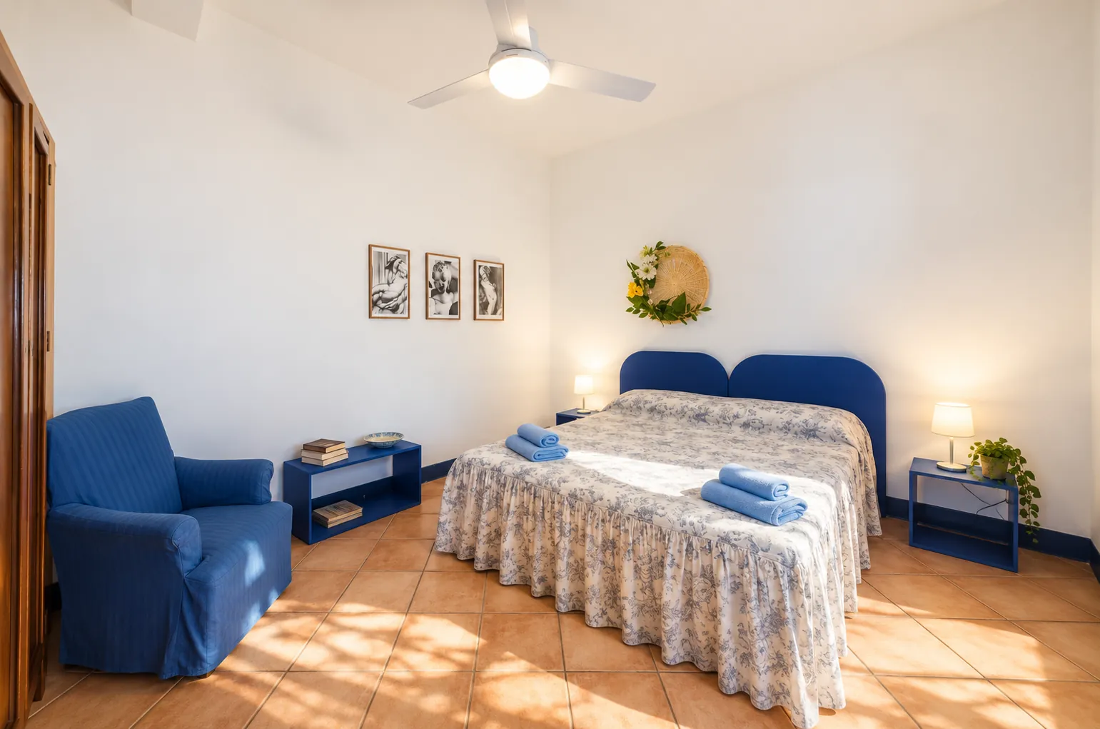 La camera matrimoniale con testiera blu e luce del mattino